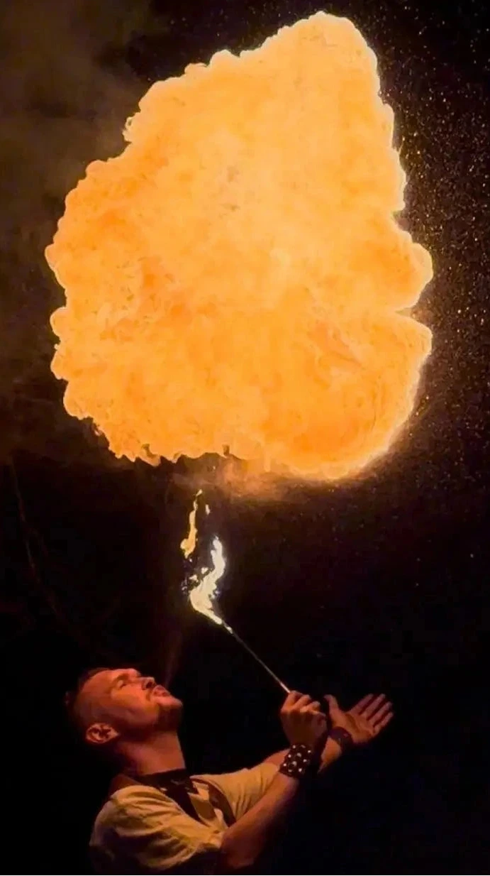 Cracheur de feu avec une énorme boule de feu au dessus de lui. La Tribe Performance, évidemment.